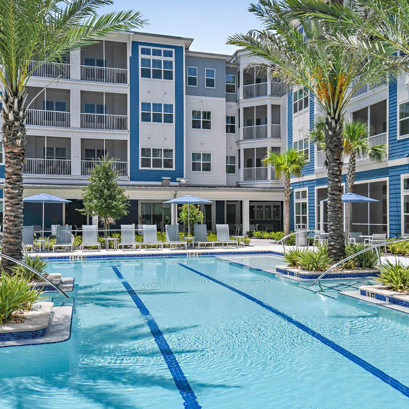 Settle into comfort at Arya at Windermere 55+ Active Adult Living a pool in front of a building