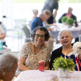 a group of women at a table with a dog